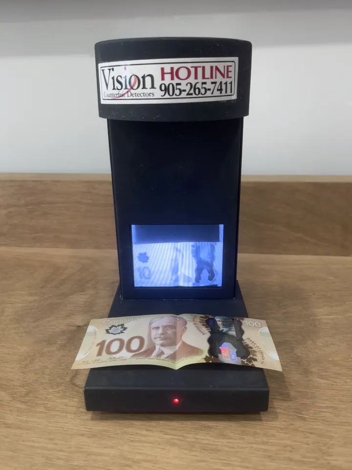 A genuine 100 dollar note being verified on the Vision detector, the infrared result showing on screen